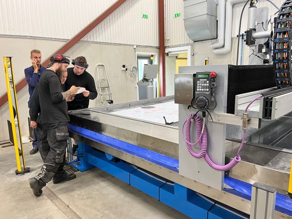Norrsken Metall operators inspect the outcome of their first waterjet test cut.